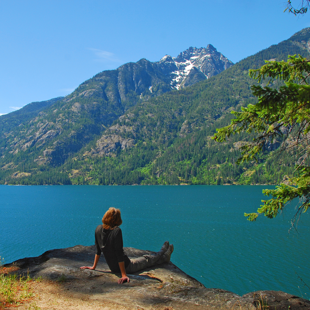 Woman contemplating on edge of Lake Chelan near Stehekin, WA